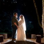 newlyweds lit up at night under the trees