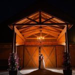 newlyweds lit at the entrance of the barn