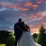 bride and groom staring at the sunset