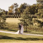 bride and groom walking along the paths at barn on oak lane